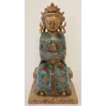 A hollow brass figurine of an Oriental Deity with cloisonné detail to robe.