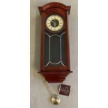 A modern Seiko, mahogany cased wall hanging quartz pendulum clock.