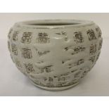 A Chinese white glazed porcelain pot of bulbous form with Chinese symbols detailed to outer bowl.