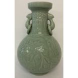 A large 2 handled celadon glaze vase of bulbous form, with floral and leaf decoration.