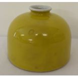 A yellow glazed beehive brush pot with signature to underside.