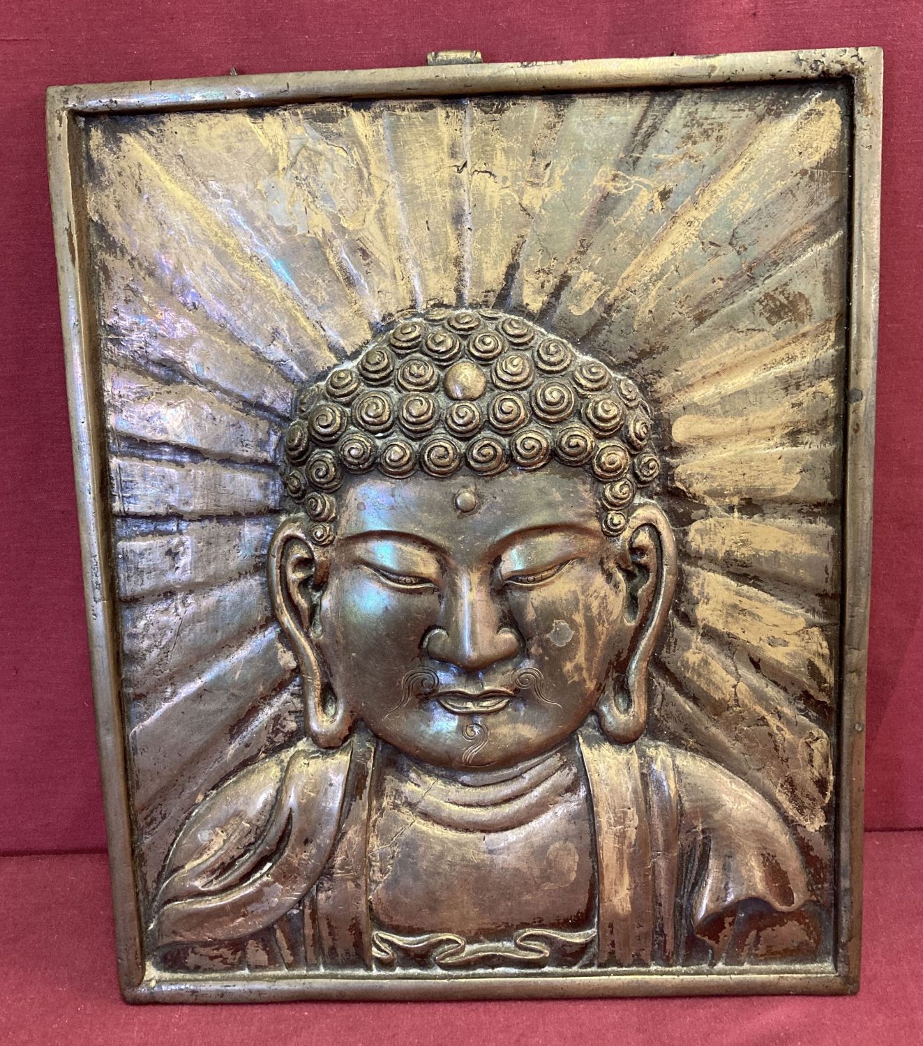 A large heavy metal wall hanging plaque depicting Buddha.