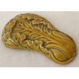A small ceramic yellow glazed scroll weight in the form of a Chinese cabbage.
