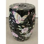 A black glazed Oriental ceramic stool with flower and bird design.