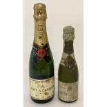 2 vintage small bottles of Champagne. A bottle by Moet & Chandon and a bottle by Pol Roger.
