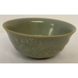 A Chinese ceramic bowl with pale blue glaze and dragon and phoenix design to outer bowl.