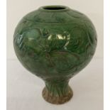 A large ceramic vase of bulbous form with deep green crackle glaze.