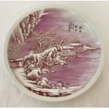 A signed, hand painted pink and white ceramic plate depicting a snow scene.