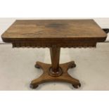 A Victorian walnut veneer games table with swivel and fold out top and fringed decoration.
