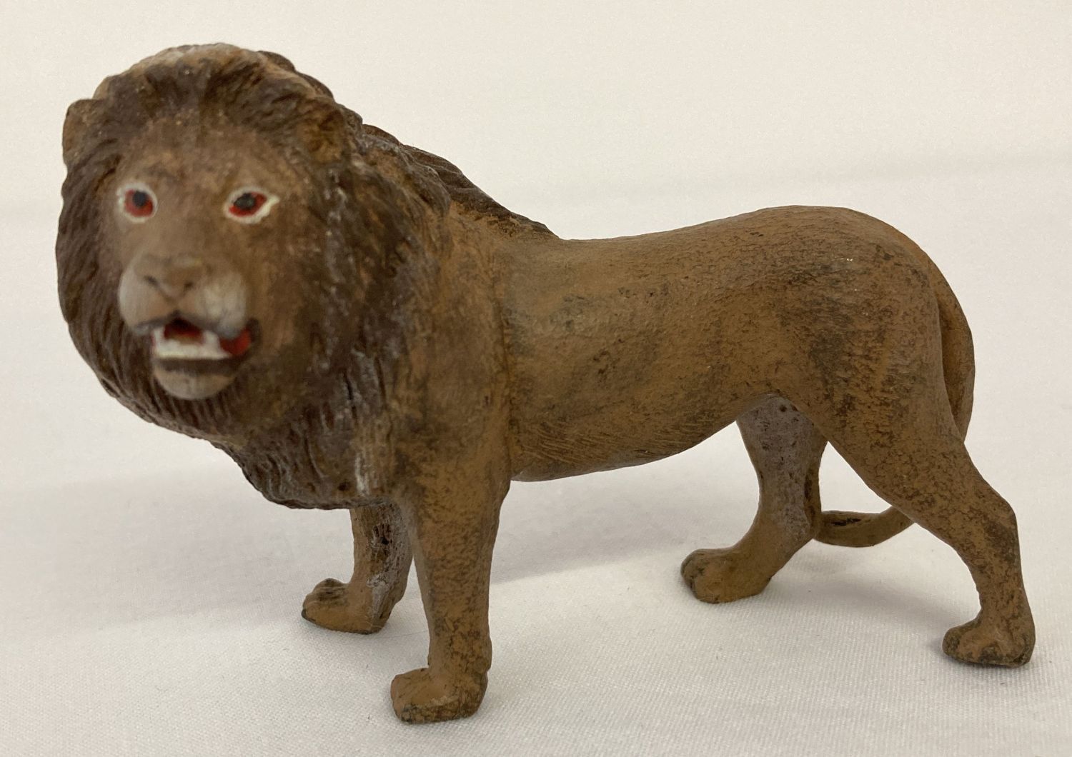 A cold painted figure of a lion.