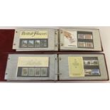 2 red folders containing a total of 49 collectors sets of Royal Mail stamps.