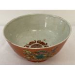 A Chinese tea bowl with orange glaze to outer bowl and fu bat detail to interior.