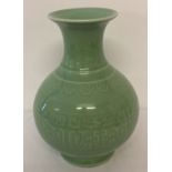 A green glazed Chinese ceramic vase of bulbous form with wide lipped neck.