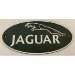 A painted cast iron oval shaped Jaguar wall plaque.