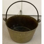 A vintage heavy brass jam pan with carry handle.