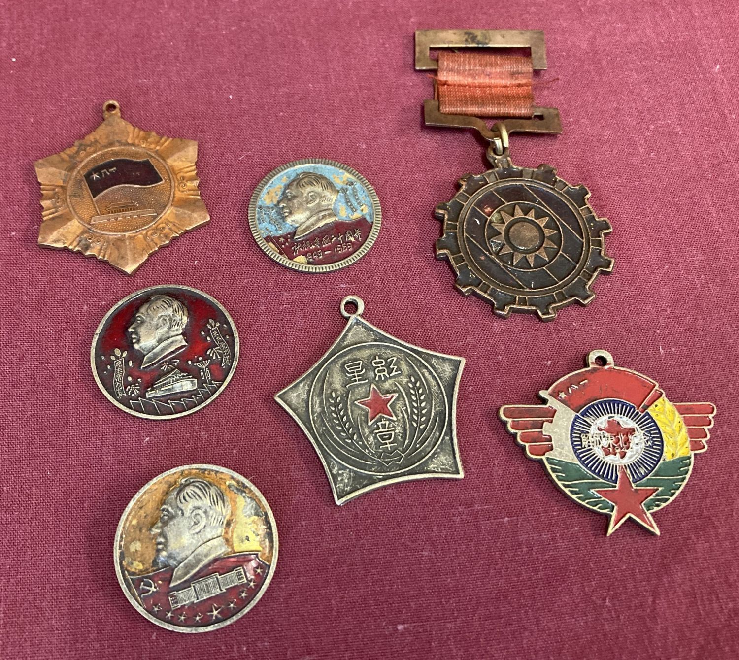 A collection of 7 vintage Chinese military medals and badges.