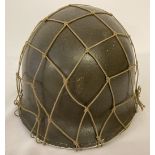 A US WWII style M1 helmet with Capac liner, cam net and painted Captains bars on the front.