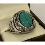 A chunky white metal dress ring set with oval turquoise cabochon.