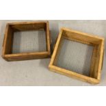 2 wooden framed agricultural sieves with wooden handles.