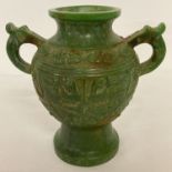 A Chinese jade 2 handled urn with Archaic design carved detail.