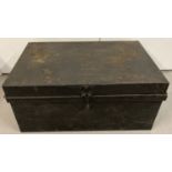 A large metal tin trunk with carry handles painted black.