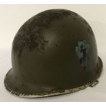 A US WWII Schlueter made MI helmet with hand painted 36th Infantry (Texas) insignia.