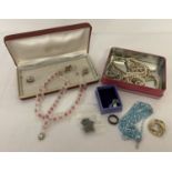 A small tin of costume jewellery to include necklaces and a silver chain.