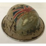 A WWII style British Brodie helmet with post war hand painted 8th Army memorial detail.