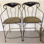 2 wrought iron curve backed high chairs with woven wicker seats.