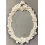 A wall hanging white painted decorative moulded framed oval mirror.