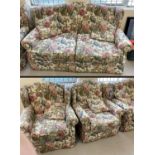A metal framed 2 seater pull out bed settee and matching arm chairs, in a floral design upholstery.