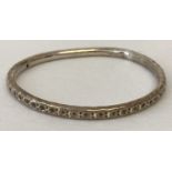 A silver bangle with punched star decoration. Very worn hallmarks, bangle has been altered.