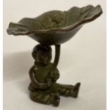 A small Meiji style bronzed figurine of a Japanese boy holding a lily pad.