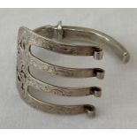 A silver bangle made from a decorative Victorian serving fork.