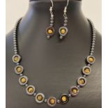 A 17" hematite and tigers eye beaded necklace and matching earrings with white metal T bar clasp.