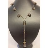 A modern design faceted smoked glass drop style necklace with silver clasp.