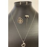 4 items of silver jewellery. A rhinoceros stick pin, a floating heart necklace, half hoop earrings