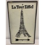 A black and white painted cast iron wall sign with directional arrow for the Eiffel Towel.