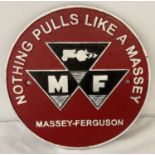 A circular painted Massey-Ferguson wall plaque in black, white and red.