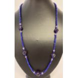 A 24" lapis and amethyst beaded necklace with white metal T bar clasp.