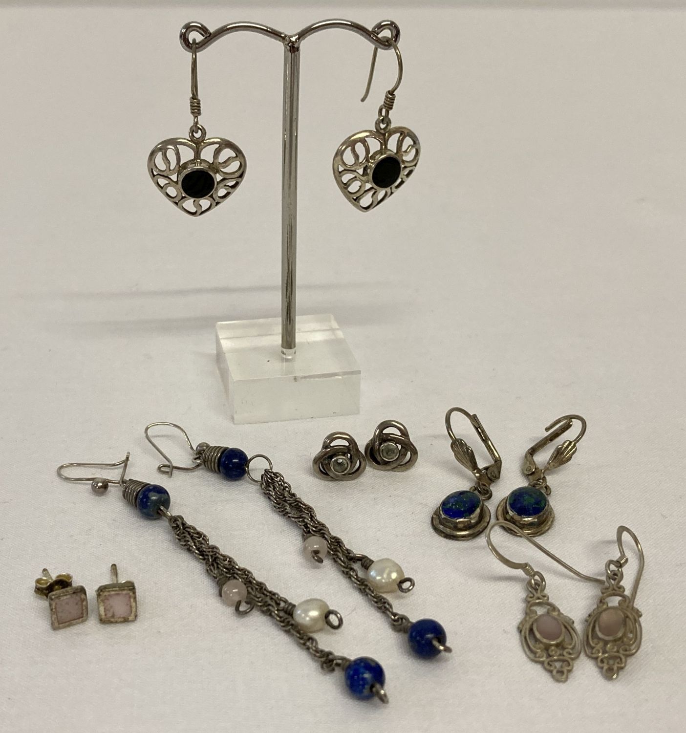 5 pairs of silver and white metal earrings in both drop and stud styles.