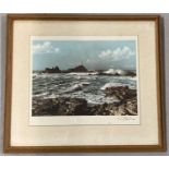 A framed and glazed vintage colour print of a lighthouse on a rocky coast.