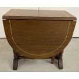 A modern style teak drop leaf gate leg coffee table with inlay detail to top and leaves.