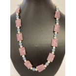 A 22" fresh water pearl necklace with pink and blue jade beads and gold tone hook clasp.