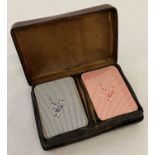 A small red leather Liberty playing card case with 2 sets of miniature playing cards, one unopened.