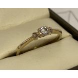 A 9ct gold .15ct diamond solitaire ring with heart detail to each side of stone.