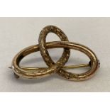 A Victorian rose gold love knot brooch with engraved decoration to front.