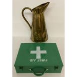 A large vintage brass jug together with a green metal first aid box with carry handle.
