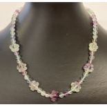 A 16" fluorite beaded necklace with spherical and flower shaped beads and sterling silver clasp.
