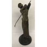 A large Art Deco bronze figurine of a female golfer on a stepped base.